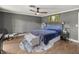 Comfortable main bedroom featuring wood floors, ceiling fan, and a large window with plenty of natural light at 4425 Se 2Nd Pl, Ocala, FL 34471