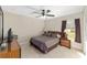 Bedroom with a ceiling fan featuring a comfortable bed, dresser, nightstand and natural light at 4826 Sw Dahlia Ct, Dunnellon, FL 34431