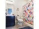 This bathroom features a blue and pink floral shower curtain and blue rug at 5718 Sw 50Th Ct, Ocala, FL 34474