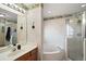 Bathroom featuring a large soaking tub, glass shower, and bright vanity lighting at 5926 Ne 62Nd Court Rd, Silver Springs, FL 34488