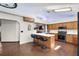 Spacious kitchen with an eat-in island, brick flooring, and ample cabinet space at 5926 Ne 62Nd Court Rd, Silver Springs, FL 34488
