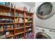 Well-organized laundry room with washer, dryer, and ample shelving for storage at 5926 Ne 62Nd Court Rd, Silver Springs, FL 34488