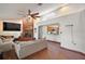Comfortable living room featuring a brick fireplace, hardwood floors, and a peek into the kitchen at 5926 Ne 62Nd Court Rd, Silver Springs, FL 34488