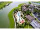 Overhead view of a resort-style community pool, lakeside clubhouse, and lush landscaping at 7234 Sw 91St Ct, Ocala, FL 34481