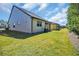 Well-maintained backyard featuring lush green grass, exterior view of the house, and screened patio at 7234 Sw 91St Ct, Ocala, FL 34481