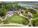 Aerial view of the community clubhouse, showcasing a golf course, parking and lake at 7234 Sw 91St Ct, Ocala, FL 34481