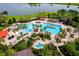 Beautiful community pool area with lush landscaping, seating, and a serene lake view at 7234 Sw 91St Ct, Ocala, FL 34481