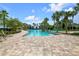 Inviting community pool area with palm trees, sun loungers, and clear blue water at 7234 Sw 91St Ct, Ocala, FL 34481
