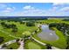 Aerial view of a lush golf course with a large pond, sand traps, and manicured greens at 7234 Sw 91St Ct, Ocala, FL 34481