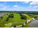 Scenic aerial of the golf course featuring greens, trees, sand traps, and nearby houses at 7234 Sw 91St Ct, Ocala, FL 34481