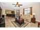Inviting living room with tile floors and an open floorplan to the eat-in kitchen, ceiling fan, and large window at 7234 Sw 91St Ct, Ocala, FL 34481