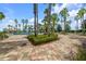 Relaxing poolside view with palm trees, lounge chairs, and a vibrant garden at 7234 Sw 91St Ct, Ocala, FL 34481