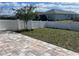 A spacious backyard with a young tree and a white vinyl fence, accessible from a paver patio at 7935 Sw 89Th Ter, Ocala, FL 34481