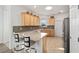 Well-lit kitchen featuring granite countertops, stainless steel appliances, and natural wood cabinetry at 7935 Sw 89Th Ter, Ocala, FL 34481