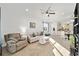 Comfortable living room with neutral decor, ceiling fan, and open access to the dining area at 7935 Sw 89Th Ter, Ocala, FL 34481