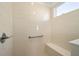 Bright bathroom walk in shower with white tiling, grab bar and bench seat at 7935 Sw 89Th Ter, Ocala, FL 34481