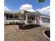 Charming single-story home featuring a well-manicured front yard, white brick exterior, and a welcoming porch with an American flag at 8665 Sw 94Th Ln # C, Ocala, FL 34481