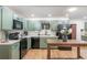 Updated kitchen with green cabinets, modern appliances, and a spacious countertop area for meal preparation at 8665 Sw 94Th Ln # C, Ocala, FL 34481