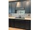 Close-up showcases the modern kitchen's cooktop, stylish backsplash, and sleek, dark cabinetry at 8825 Sw 57Th Place Rd, Ocala, FL 34481