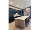 A modern kitchen features an oversized island with seating, stainless steel appliances, and stylish dark cabinets at 8825 Sw 57Th Place Rd, Ocala, FL 34481