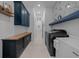 Well-organized laundry room featuring modern appliances, cabinetry, shelving, and stylish tile flooring at 8825 Sw 57Th Place Rd, Ocala, FL 34481