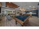 An open-concept layout featuring a pool table, living room, and kitchen area perfect for social gatherings at 8825 Sw 57Th Place Rd, Ocala, FL 34481