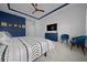 Stylish main bedroom features dark blue accent wall, TV, and comfortable bed at 8825 Sw 57Th Place Rd, Ocala, FL 34481