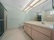 Neutral-colored bathroom featuring a shower, modern lighting, and a large mirror above the vanity at 8832 Sw 108Th St, Ocala, FL 34481