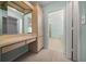 Neutral bathroom vanity featuring built-in storage and an adjacent doorway leading to a tiled walk-in shower at 8832 Sw 108Th St, Ocala, FL 34481
