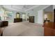 Main bedroom featuring tray ceiling, neutral carpeting and multiple windows with great natural light at 8832 Sw 108Th St, Ocala, FL 34481