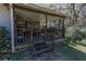 Covered porch with wooden railing, grill, and outdoor seating at 9108 Sw 197Th Cir, Dunnellon, FL 34432