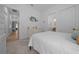 Bright bedroom with white walls, carpet flooring, with a decorative dresser, and doorway leading to bathroom at 8825 Sw 57Th Place Rd, Ocala, FL 34481