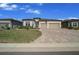 Charming home features a well-manicured lawn, colorful plants, and a brick paver driveway, enhancing its curb appeal at 8825 Sw 57Th Place Rd, Ocala, FL 34481