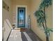 Inviting entryway features a stylish blue door, decorative plants, and a 'welcome' sign, creating a warm and friendly ambiance at 8825 Sw 57Th Place Rd, Ocala, FL 34481