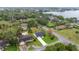 Aerial view of the property with mature trees, lush lawns, and a tranquil lake nearby at 1000 Woodward Oaks Cir, Eustis, FL 32726