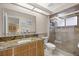 Modern bathroom with a granite countertop, walk-in shower, and updated fixtures at 1000 Woodward Oaks Cir, Eustis, FL 32726