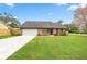 Charming single-story home with a well-manicured lawn and an attached two-car garage at 1000 Woodward Oaks Cir, Eustis, FL 32726
