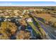 Aerial view showcases the home's location, surrounded by mature trees, neighboring properties, and a road, providing a sense of community at 10495 Sw 100Th Ave, Ocala, FL 34481