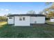 The back exterior is equipped with white siding, an outdoor water spigot, and a well-kept lawn at 10495 Sw 100Th Ave, Ocala, FL 34481