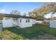 The back exterior of the home features white siding and a gated fence in the backyard at 10495 Sw 100Th Ave, Ocala, FL 34481