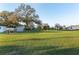 Expansive backyard showcasing a lush green lawn, mature trees, and outbuildings, providing ample space for recreation and enjoyment at 10495 Sw 100Th Ave, Ocala, FL 34481