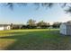 Expansive backyard with green grass, shed, and chain link fence for outdoor enjoyment at 10495 Sw 100Th Ave, Ocala, FL 34481