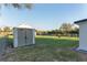 This is a backyard view of the storage shed on well maintained lawn at 10495 Sw 100Th Ave, Ocala, FL 34481