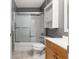 Updated bathroom features shower-tub combo with sliding glass doors and built-in storage at 10495 Sw 100Th Ave, Ocala, FL 34481