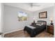 This bedroom features natural light from the window, ceiling fan and wood-look flooring at 10495 Sw 100Th Ave, Ocala, FL 34481