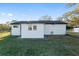 View of the back of the house, featuring white siding, well-kept grass, and a fenced yard at 10495 Sw 100Th Ave, Ocala, FL 34481