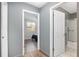 Hallway featuring views into a well-lit bathroom and a bedroom, enhancing accessibility and flow at 10495 Sw 100Th Ave, Ocala, FL 34481