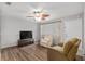 Cozy living room with hardwood floors, ceiling fan, and comfortable seating at 10495 Sw 100Th Ave, Ocala, FL 34481