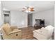 Cozy living room with hardwood floors, ceiling fan, and comfortable seating at 10495 Sw 100Th Ave, Ocala, FL 34481