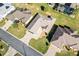 Aerial view of a well-manicured home featuring a pristine lawn, mature landscaping, and a paved driveway in a quiet neighborhood at 11013 Se 169Th Pl, Summerfield, FL 34491